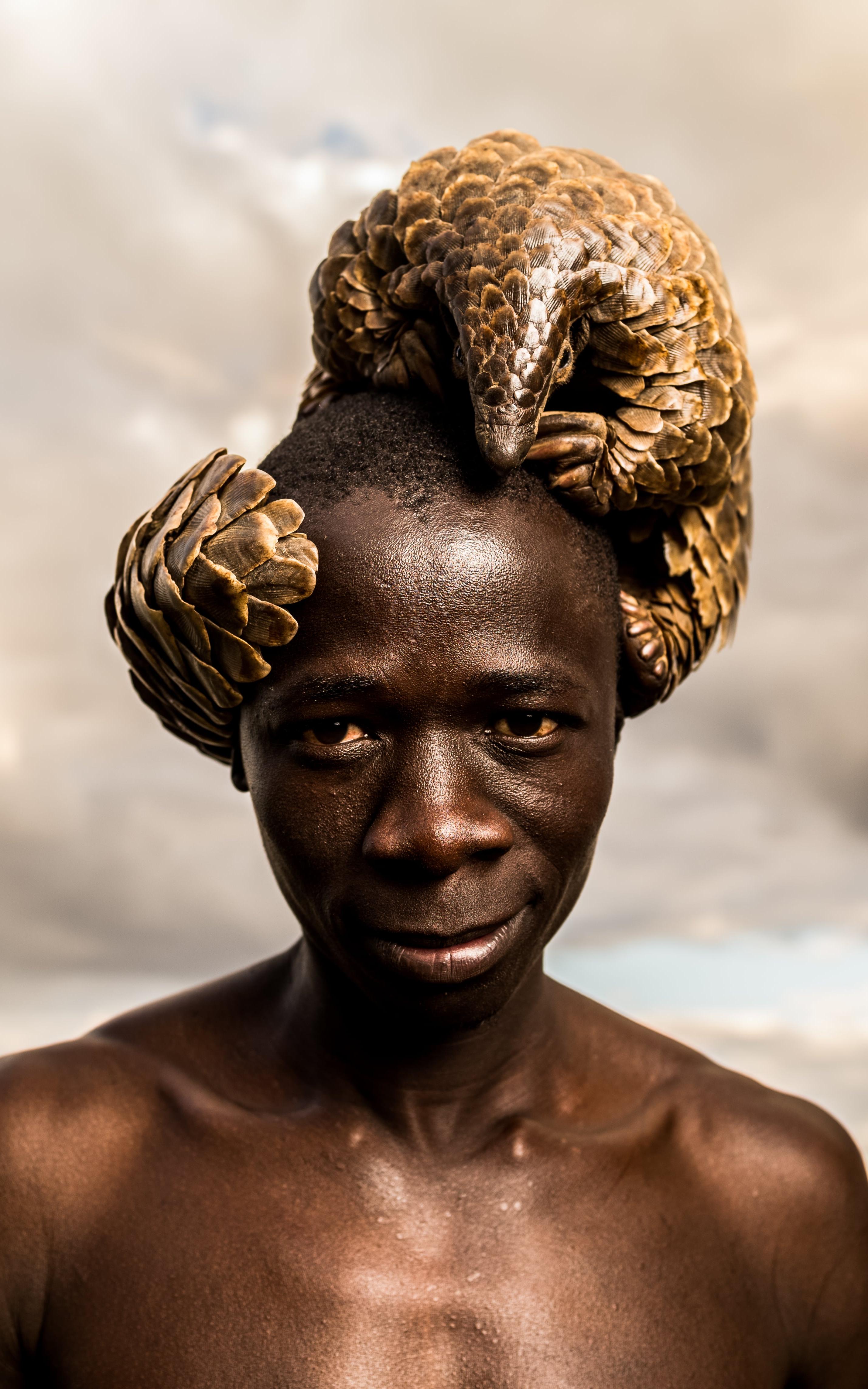 Man with a pangolin on his head
