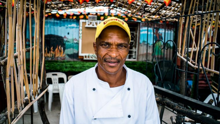 Black man smiling into camera.