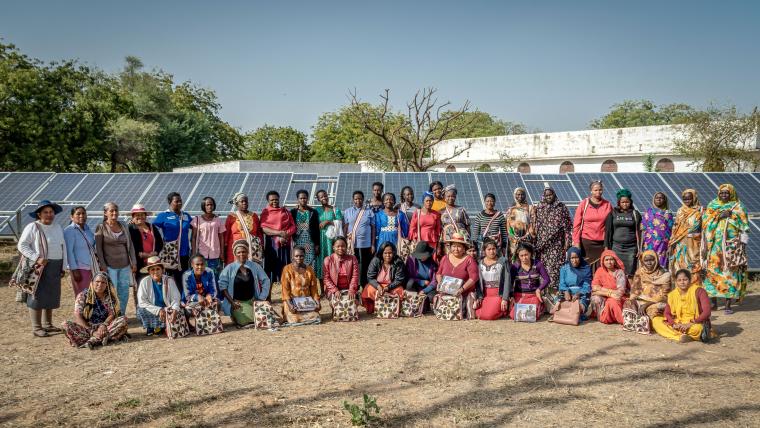 Beautiful News-Women standing in front of solar panels.